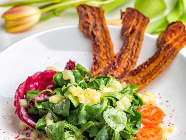 Ein kreatives Gericht mit knusprigem Bacon und frischem Salat - ein Genuss für die Sinne.
