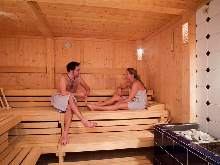 Eine Mann und eine Frau unterhalten sich in einer Sauna im Hotel Edelweiß